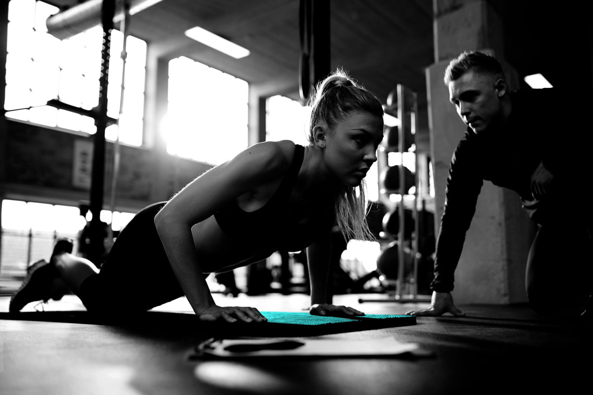 Male personal trainer coaching a young woman