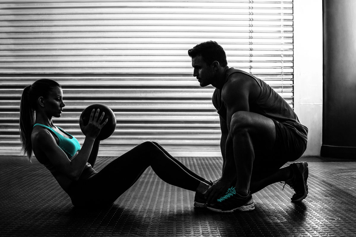 Male personal trainer with fit female client